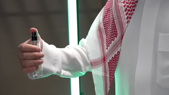 رجل يرتدي الثوب السعودي يرش العطر، لقطة قريبة.