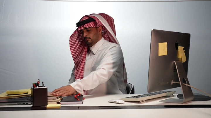 رجل سعودي في مكتب حديث، لقطة من زاوية جانبية.