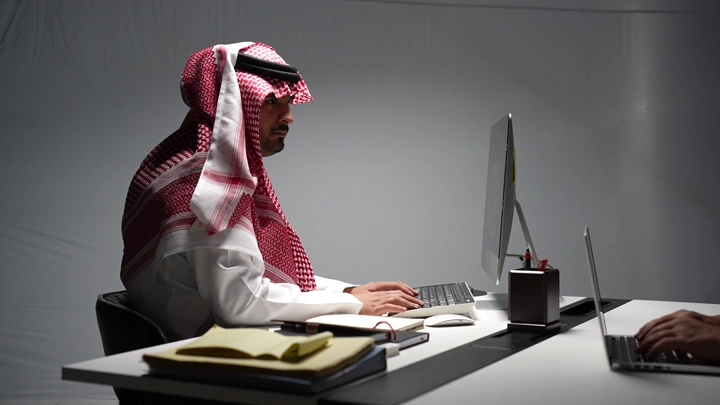 رجل سعودي في مكتب حديث، لقطة جانبية.