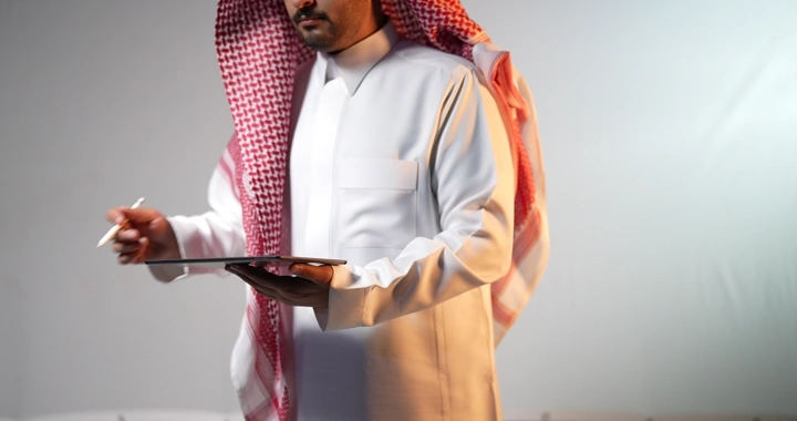 رجل سعودي يعمل على ايباد في استوديو تصوير.