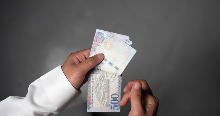 رجل يعد النقود السعودية، لقطة مقربة.