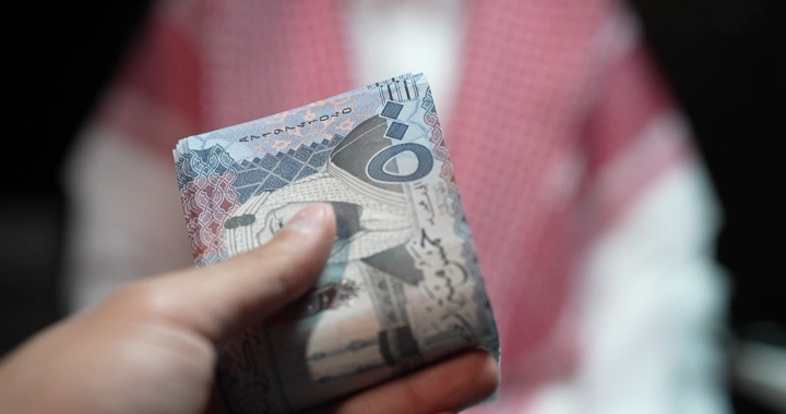 رجل سعودي يعد النقود في يده، لقطة قريبة.