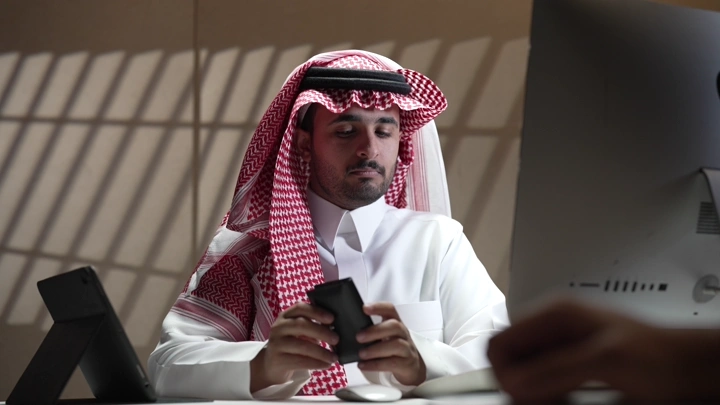 رجل سعودي في مكتب حديث، لقطة داخلية