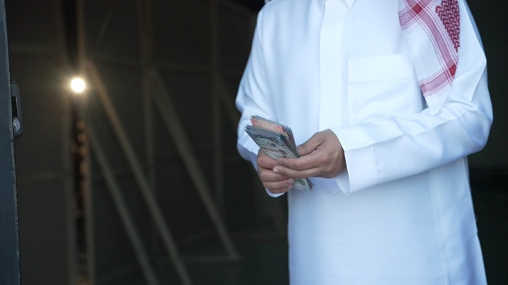 رجل سعودي يعد النقود في الداخل، لقطة قريبة.