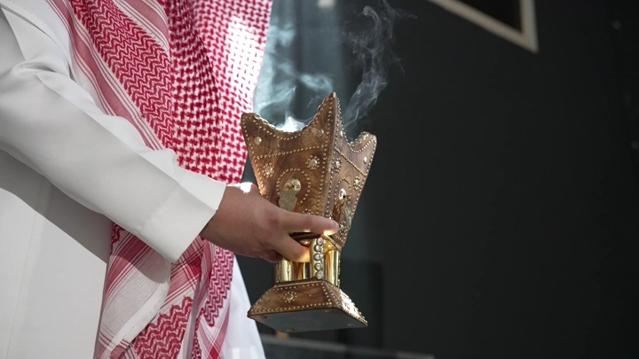 رجل سعودي يحمل مبخرة تقليدية، لقطة مقربة.