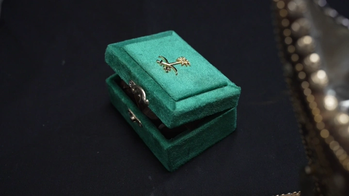 صندوق عود أخضر مفتوح على سطح أسود، لقطة قريبة.