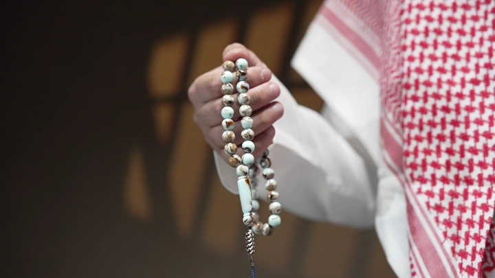 رجل سعودي يحمل سبحة في يده، لقطة قريبة.