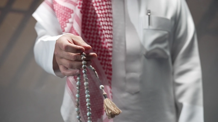 رجل سعودي يحمل سبحة في يده، لقطة قريبة.