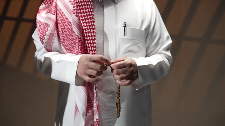 رجل سعودي يحمل سبحة في يده، لقطة قريبة.