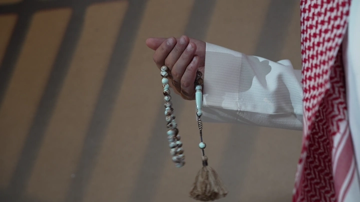 رجل سعودي يحمل سبحة في يده، لقطة قريبة.