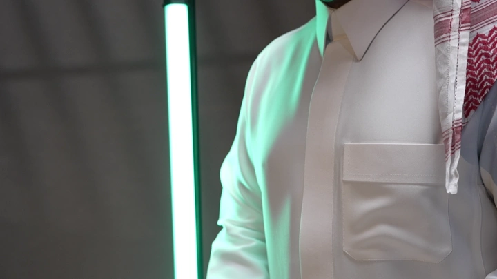 رجل سعودي يرتدي ثوبًا وشماغ يرش العطر، لقطة مقربة.