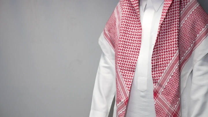 رجل يرتدي ثوبًا  وشماغ ويتصافحة سلام اتفاق ، لقطة مقربة.