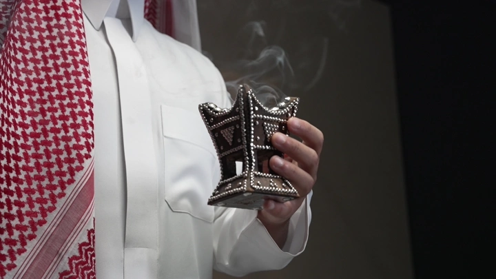 رجل سعودي يحمل مبخرة تقليدية، لقطة مقربة.
