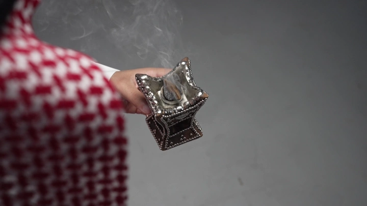 رجل سعودي يحمل مبخرة تقليدية، لقطة مقربة.