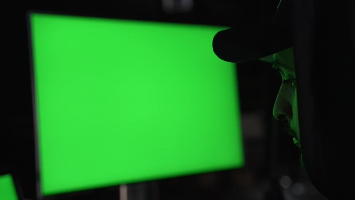 رجل يعمل على شاشة كروما خضراء في استوديو، لقطة جانبية.