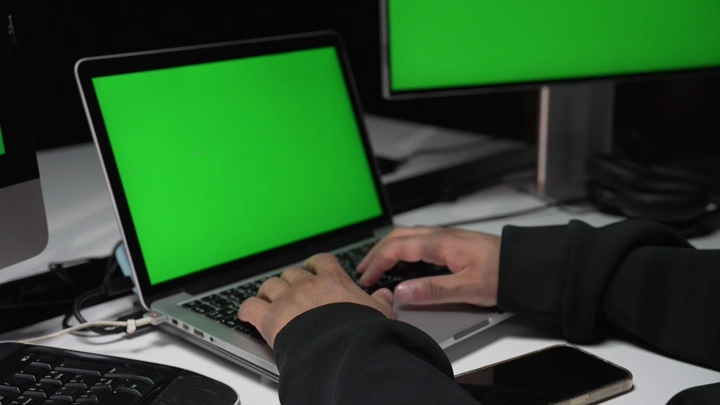 رجل يعمل على حاسوب بشاشة كروما خضراء، لقطة قريبة.