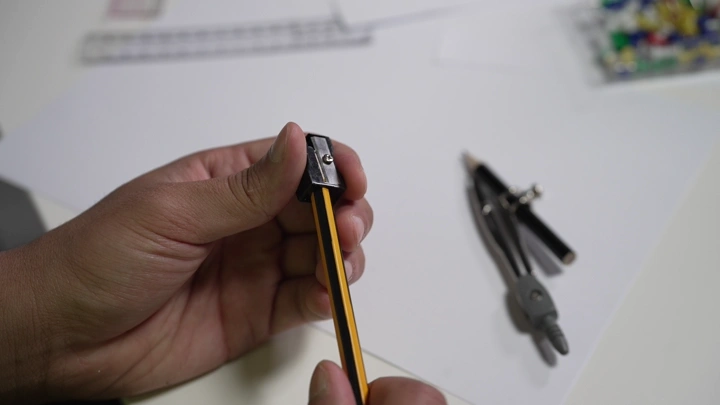 شخص يبرى قلم رصاص على مكتب، لقطة قريبة.