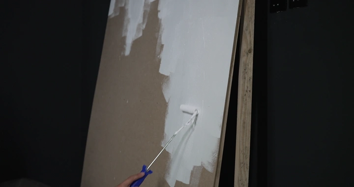 رجل يطلي الجدار باللون الأبيض، لقطة قريبة.