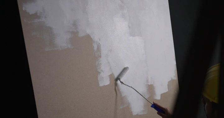 رجل يطلي الجدار باللون الأبيض، لقطة قريبة.
