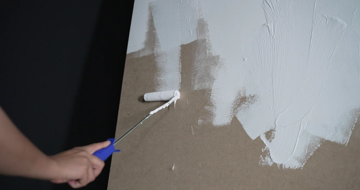 رجل يطلي الجدار باللون الأبيض، لقطة مقربة.