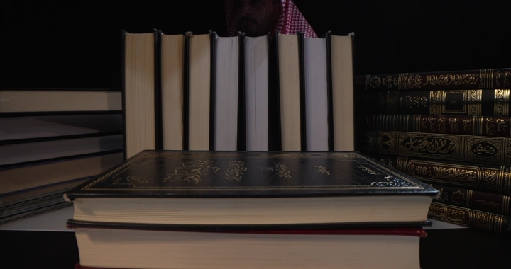 كتب مرتبة على رف في مكتبة، لقطة قريبة.