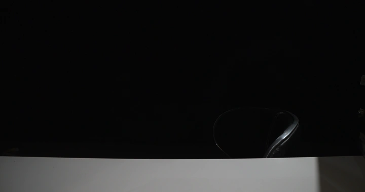 ترتيب كتب على مكتب أبيض مع كرسي في غرفة مظلمة، لقطة منخفضة الإضاءة.