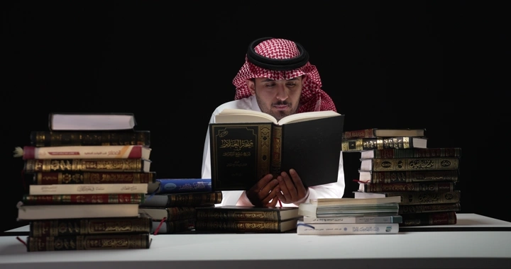 رجل يقرأ بين مجموعة من الكتب، لقطة واسعة.