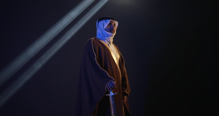 رجل يرتدي بشت تقليدية ويحمل سيفًا، إضاءة درامية.