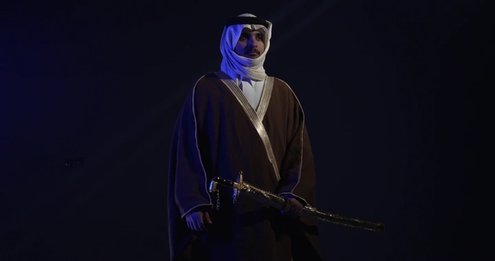 رجل يرتدي الزي التقليدي حاملًا سيفًا في إضاءة خافتة، لقطة استوديو.