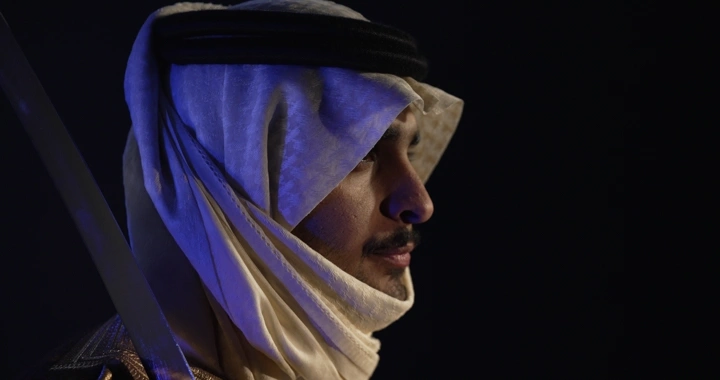 رجل يرتدي الزي التقليدي مع سيف، صورة جانبية.