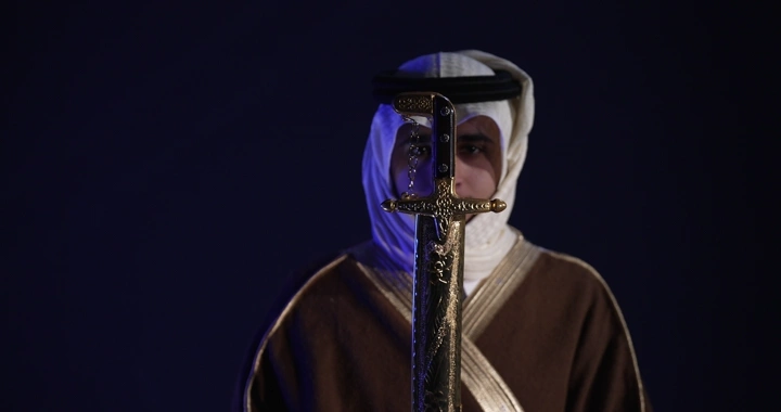 رجل يرتدي الزي التقليدي يحمل سيفًا، لقطة قريبة.