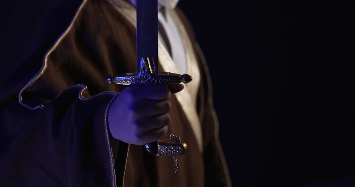 رجل يحمل سيفًا في الظلام، لقطة مقربة.