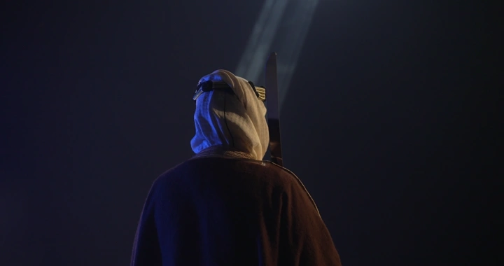 رجل يرتدي بشت في الليل، لقطة من الخلف.