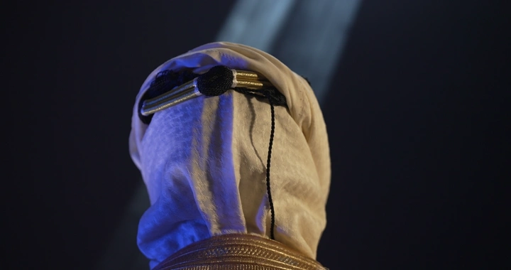 رجل يرتدي عقال مقصب في إضاءة سينمائيه.، لقطة خلفية.