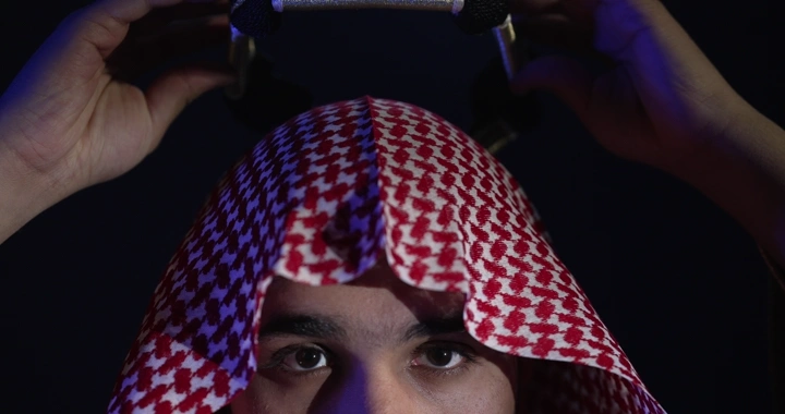 رجل يرتدي عقال مقصب في إضاءة خافتة، لقطة مقربة.