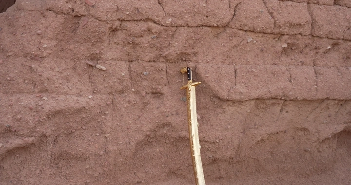 جدار طيني مع سيف تقليدي، لقطة قريبة.