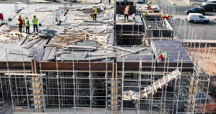 Construction workers at a building site, aerial shot.