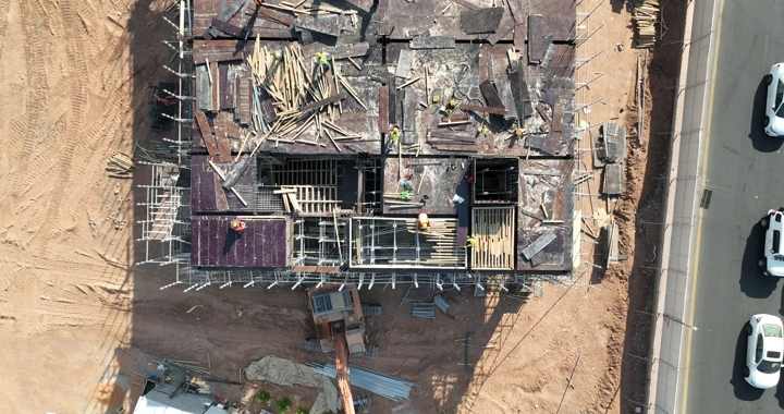 Construction workers at a building site, aerial shot.