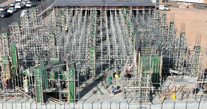 Construction workers at a busy construction site, aerial shot.