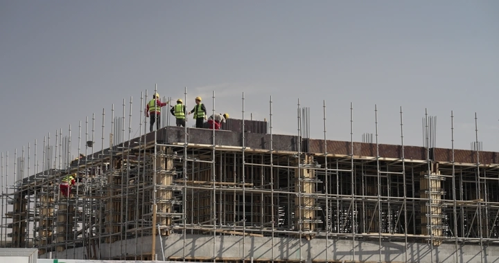 Construction workers on scaffolding at a building site, daytime shot.