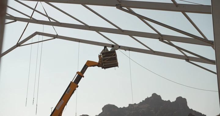 A construction worker using a crane, shot from a low angle.