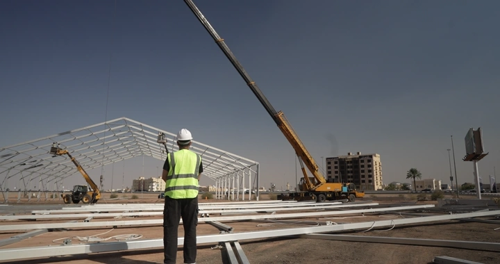Engineer wearing helmet and vest at construction site, daytime shot.
