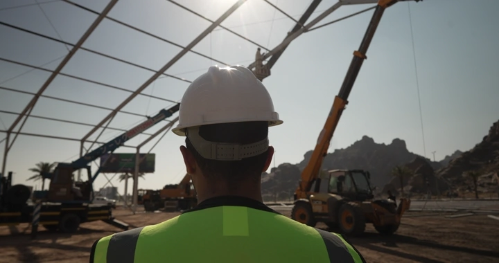 Engineer wearing a helmet at a construction site, rear view shot.