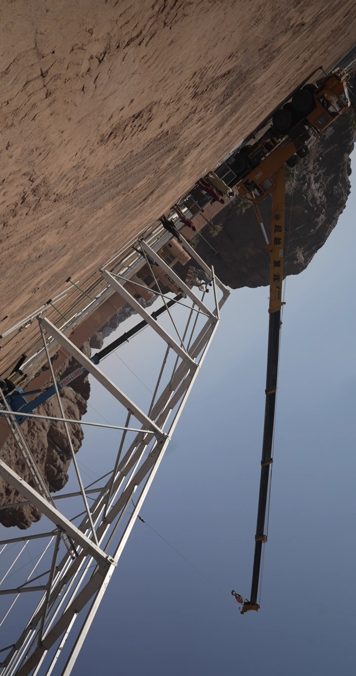 Crane at a desert construction site, wide-angle shot.