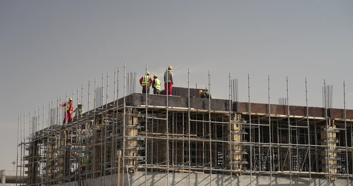 Construction workers on scaffolding at a construction site, daytime shot.