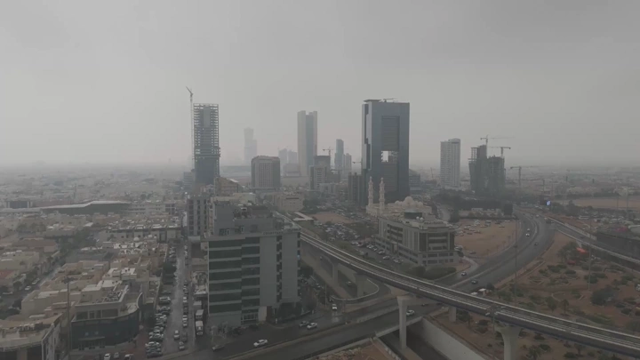 مدينة مع أبراج وطرق سريعة تحت سماء غائمة، لقطة جوية.