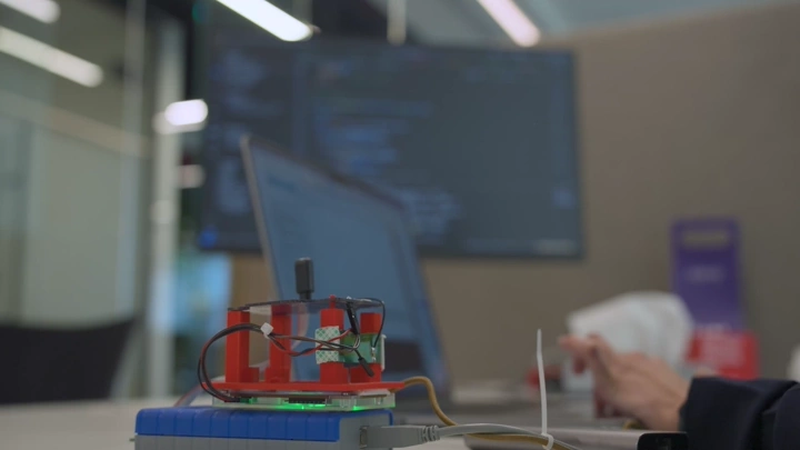 جهاز إلكتروني على مكتب في شركة، لقطة داخلية.