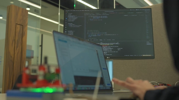 شاشة كمبيوتر تعرض كود برمجي في مكتب حديث، لقطة قريبة.
