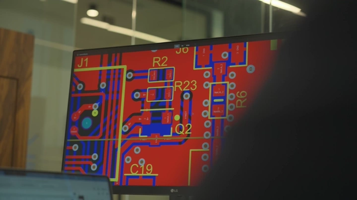 شاشة تعرض تصميم لوحة إلكترونية في مكتب حديث، لقطة داخلية.