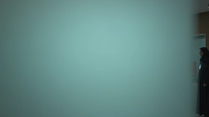 موظفة تقف في مكتب حديث، لقطة جانبية.